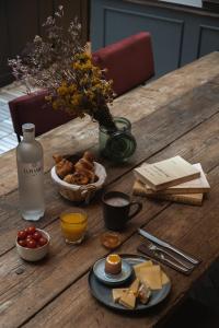 une table en bois avec de la nourriture et un vase de fleurs dans l'établissement La Planque Hotel, à Paris