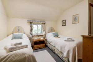 a bedroom with two beds and a window at Marris Cottage in Grimsby