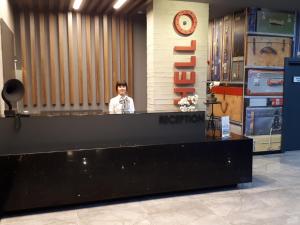 a man standing behind a reception desk in a store at Ramira City Hotel - Adult Only (16+) in Alanya