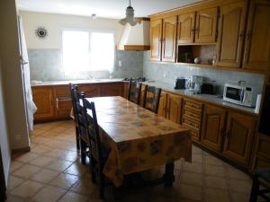 a kitchen with a table with chairs and a microwave at Maison tout confort avec piscine à Bedarrides in Bédarrides +5 photos