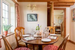 a dining room with a wooden table and chairs at Marris Cottage in Grimsby