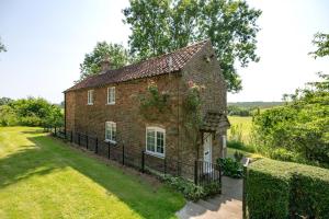 an old brick house with a fence around it at Marris Cottage in Grimsby