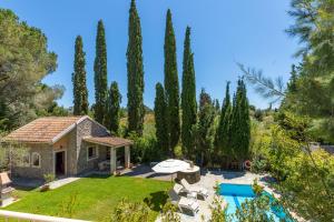 - une vue extérieure sur une villa avec une piscine et des arbres dans l'établissement Petrinos Cottage, à Dafnila