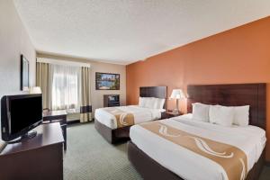 a hotel room with two beds and a flat screen tv at Quality Inn Cedar Park - Austin Northwest in Cedar Park