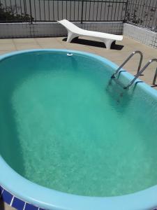 a large blue bath tub with a chair in the background at Portugal Flat in João Pessoa