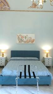 a bedroom with a blue bed with two night stands at i 2 Capitani in Riposto