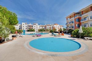 a large swimming pool in a resort with buildings at Albufeira Modern with pool by Homing in Albufeira
