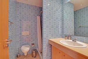 a blue tiled bathroom with a sink and a toilet at Albufeira Modern with pool by Homing in Albufeira +21 photos