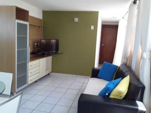 uma sala de estar com um sofá e uma televisão em Portugal Flat em João Pessoa