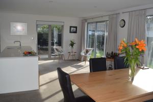 a kitchen and dining room with a table and chairs at Bed & Breakfast in the Heart of Fendalton in Christchurch