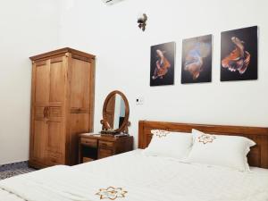 een slaapkamer met een bed en wat foto's aan de muur bij Nhà nghỉ Phúc Anh - Bắc Kạn in Bak Kan