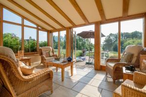 a conservatory with chairs and a table and windows at Little Walk Cottage in Grimsby