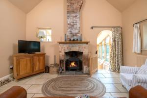 sala de estar con chimenea y TV en Little Walk Cottage, en Grimsby