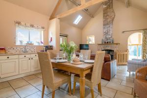 a kitchen and dining room with a wooden table and chairs at Little Walk Cottage in Grimsby