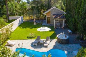 - une vue aérienne sur une cour avec une piscine et un parasol dans l'établissement Petrinos Cottage, à Dafnila 21 autres photos
