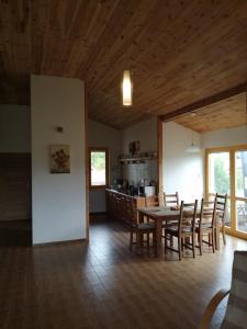 a dining room and kitchen with a table and chairs at Słonecznikowa Zagroda in Debina +8 photos