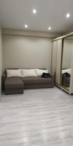 a living room with a brown couch and mirrors at Апартаменты премиум класса у цирка in Chişinău
