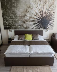 a bedroom with a large bed with a painting on the wall at Főnix Apartman in Lenti