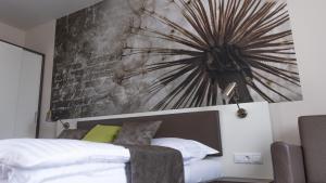 a bedroom with a bed and a large painting on the wall at Főnix Apartman in Lenti