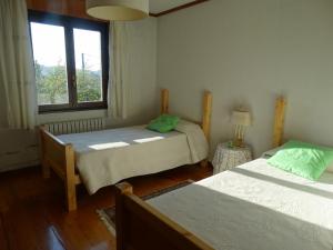 a small room with two beds and a window at La Casa de la Carpintería in Renedo de Piélagos