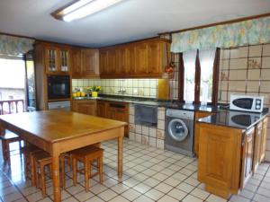 - une cuisine avec des placards en bois, une table et une table dans l'établissement La Casa de la Carpintería, à Renedo de Piélagos