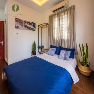 una camera da letto con un grande letto blu con cuscini blu di Cactusland Homestay - Tran Hung Dao ad Ho Chi Minh
