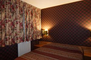ein Hotelzimmer mit 2 Betten und einem Vorhang in der Unterkunft Suite sulle piste in Faidello