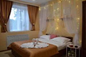 a bedroom with a bed with two swans on it at City Hotel in Gomel