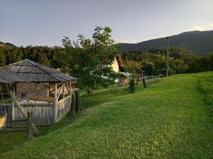 un edificio en una colina con un campo de césped en Country House Roman, en Doboj