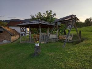 a wooden gazebo in the middle of a yard at Country House Roman in Doboj