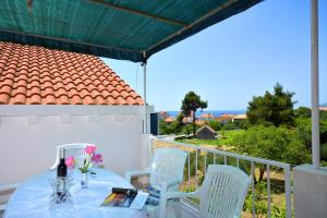 a table and chairs on a balcony with a view of the ocean at Apartments Bjanka in Žuljana
