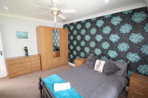 1 dormitorio con 1 cama y una pared con flores azules en Hounslow House en Hounslow