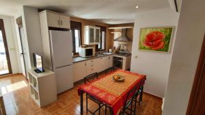 Una pequeña cocina con una mesa y un refrigerador. en Exclusivo LOFT en el corazón de Casarabonela!, en Casarabonela