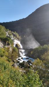 eine Gruppe von Menschen, die auf einer Brücke über einen Fluss stehen in der Unterkunft Oldevatn Camping in Olden