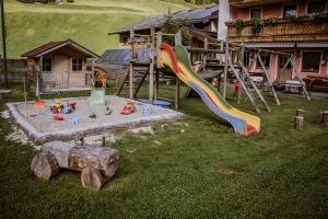 a playground with a slide and play equipment in a yard at Gasthof Haidbach in Mittersill