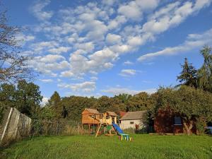un parco giochi in un campo con un cielo nuvoloso di Ranczo Drażniew a Drażniew
