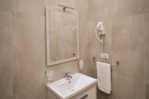 y baño con lavabo y espejo. en In Center Hotel, en Tirana