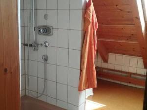 モースにあるFerienwohnung Ingeborg Schmitzの壁に掛けられたオレンジのタオル付きのシャワーブース