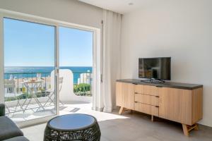a living room with a tv and a large window at Waterside Village - Sea View Apartment in Alagoas