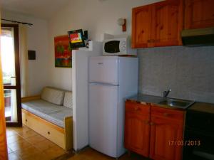 a kitchen with a white refrigerator and a microwave at Casa Michela in Torre Dei Corsari