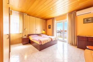 1 dormitorio con cama y ventana grande en Studio Apartments Apolonia, en Novalja