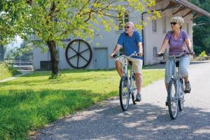 un hombre y una mujer montando bicicletas por un camino en Dorint Parkhotel Bad Zurzach, en Bad Zurzach