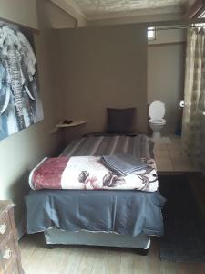 a bedroom with a bed and a toilet at Silvermoon in Nigel