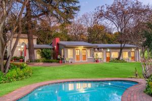 a house with a swimming pool in front of a yard at The Haystack On Homestead in Johannesburg
