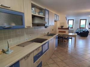 a kitchen with blue cabinets and a living room at La Meisoun de Lanta - cir n 0003 in Introd