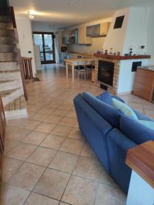 a living room with a blue couch and a kitchen at La Meisoun de Lanta - cir n 0003 in Introd