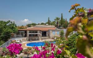 a house with a swimming pool and some flowers at Cyprus Villages Hotel & Restaurant - Central Location - Bed & Breakfast - With Access To Pool And Stunning Views in Tochni