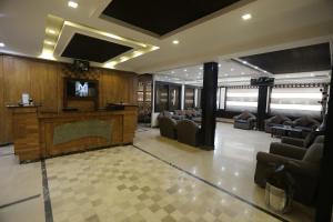 a lobby with couches and a television on a wall at City Centre Suites in Multan