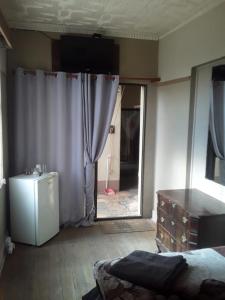 een kamer met een bed, een koelkast en een raam bij Silvermoon in Nigel