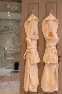 two white robes hanging on a wall in a bathroom at The Coach and Horses in Clitheroe +17 photos